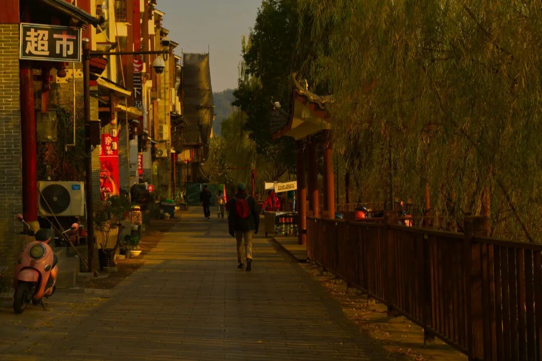 A man riding a bike down a street next to tall buildings